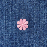 Pink flower patch on blue denim fabric