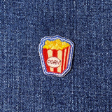 Popcorn-themed patch on a denim background
