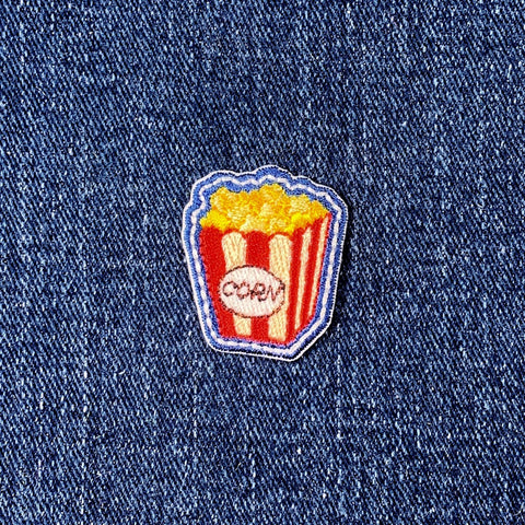 Popcorn-themed patch on a denim background