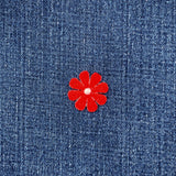 Red flower patch on blue denim fabric