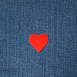 Red heart patch on blue denim fabric
