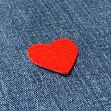 Red heart-shaped patch on blue denim fabric