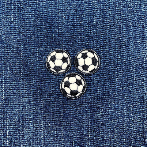 Three soccer ball patches on a denim background