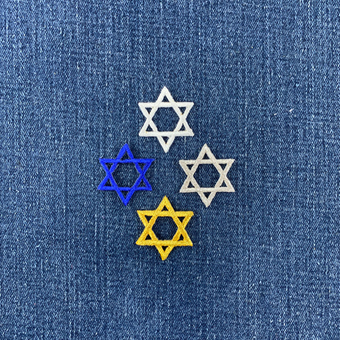 Four embroidered Star of David patches on a blue denim fabric background.