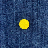 Gold tennis ball patch on a blue denim fabric background