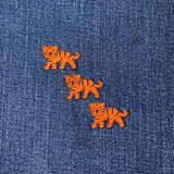 three mini tiger patches on a denim background