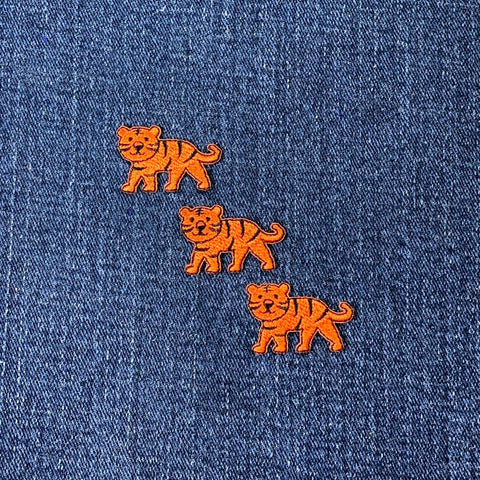 three mini tiger patches on a denim background