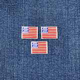 Three mini American flag patches on a denim background