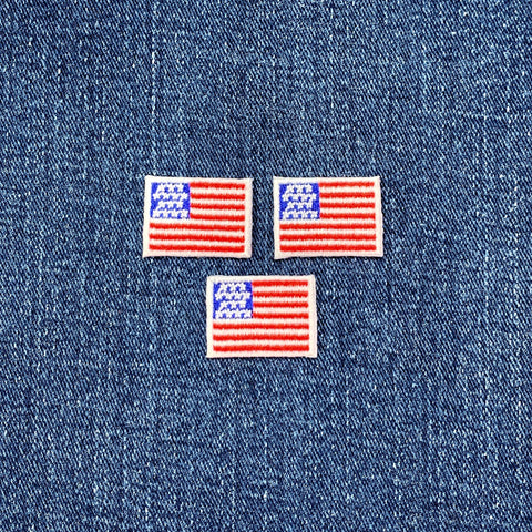 Three mini American flag patches on a denim background