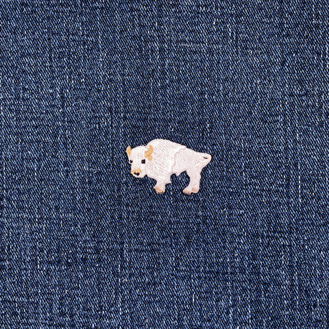 White buffalo patch on a blue denim fabric background