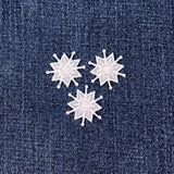Three snow-shaped patches on a denim background