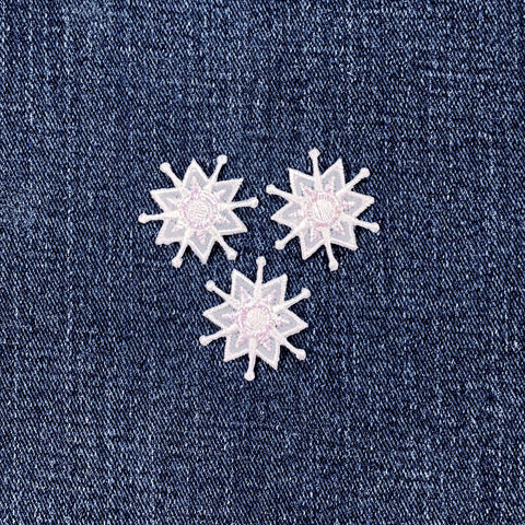 Three snow-shaped patches on a denim background