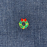 Embroidered Christmas wreath patch with red bow on denim fabric