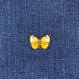 Yellow butterfly patch on a blue denim background