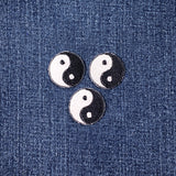 Three mini yin yang symbol patches on a denim background