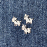 Three zebra-shaped patches on a denim background