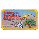 A patch featuring an illustration of a desert landscape with a tree and the text 'I SURVIVED THE GREAT MOJAVE DESERT'. There is a sun in the background and a mountain range.