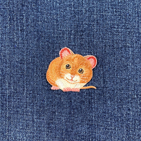 Embroidered mouse patch on a denim background