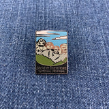 A pin badge featuring an illustration of Mount Rushmore National Memorial with the text 'Mount Rushmore National Memorial' at the bottom on a denim background