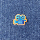 Embroidered patch of a camera on denim fabric