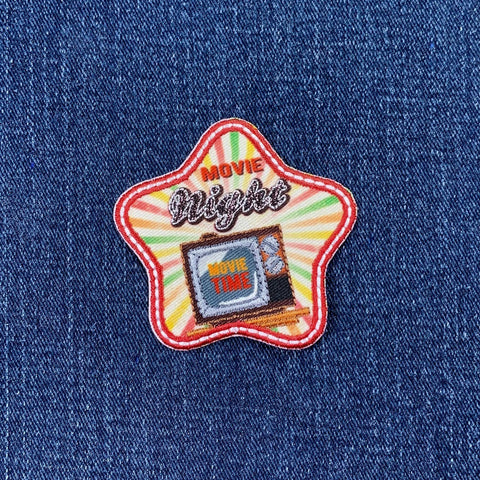 Star-shaped patch with 'Movie Night' text and a television graphic on denim fabric.