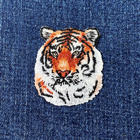 Embroidered tiger applique patch with a realistic design on denim fabric