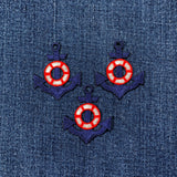 Three embroidered anchor and life buoy designs on a denim fabric background
