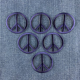 6 navy blue peace sign patches displayed on a denim background