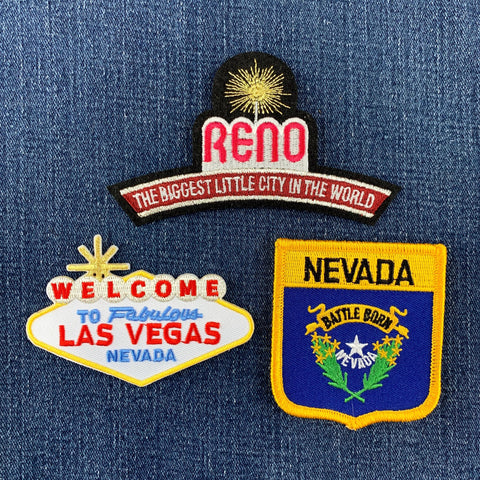 Three Nevada-themed patches on a denim background