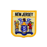 A shield-shaped embroidered patch with the text 'NEW JERSEY' at the top. The patch features an illustration of a figure in a yellow robe, a figure in a red costume, and a blue shield with a lion and unicorn.