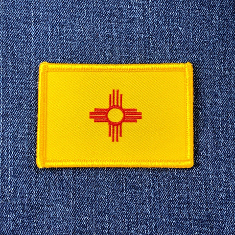 Yellow New Mexico patch with red emblem on a blue denim background