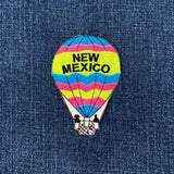 Colorful hot air balloon patch with 'New Mexico' text on denim fabric