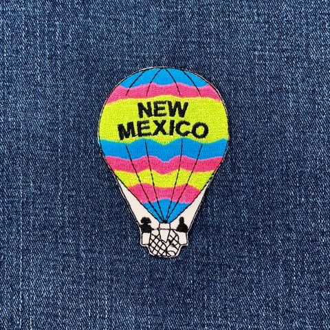 Colorful hot air balloon patch with 'New Mexico' text on denim fabric