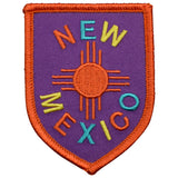 Patch with 'New Mexico' text and zia symbol on a purple background