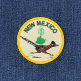 Embroidered patch with 'New Mexico' text and a roadrunner on blue denim fabric.