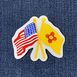 A patch featuring crossed American and New Mexico state flags on a denim background.