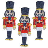 Three embroidered applique patches of nutcracker badges, designed with a Christmas holiday theme, to be ironed onto fabric.