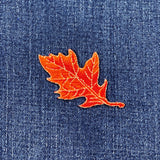 Orange leaf patch on blue denim fabric