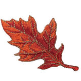 Embroidered orange maple leaf on a white background
