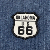 Oklahoma route 66 patch shaped like a highway sign and displayed on a denim background