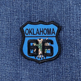 Patch with 'Oklahoma 66' highway sign with state flag design details on a denim background