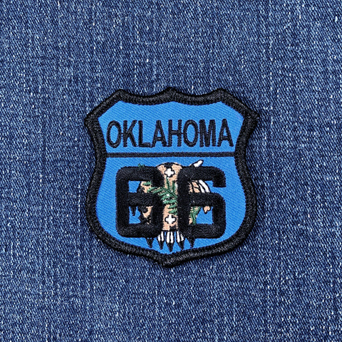 Patch with 'Oklahoma 66' highway sign with state flag design details on a denim background