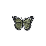 Butterfly-shaped patch with green and black design on a white background