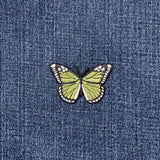 Green butterfly patch on a denim background