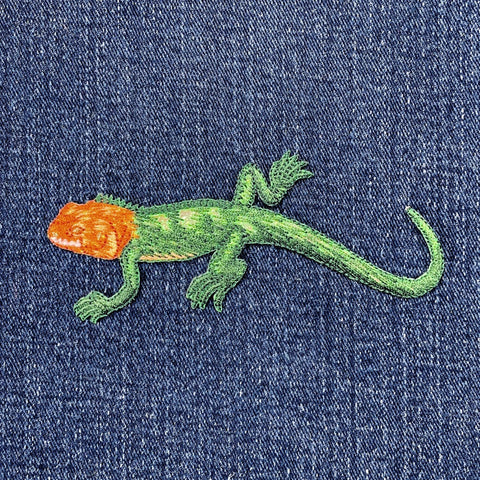 Embroidered lizard design on denim fabric