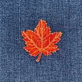 orange maple leaf patch on blue denim fabric