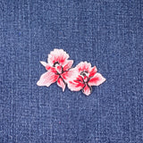 Pink orchid embroidered patch on blue denim fabric