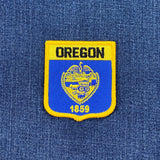 Oregon state patch with 'OREGON' and '1859' text on a blue background