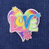 Colorful 'LOVE' patch with flowers on a denim background
