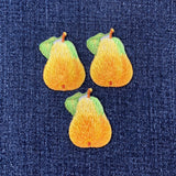 Three embroidered pear patches on a denim background